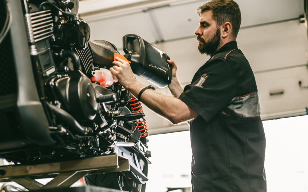 Motorcycle,Mechanic,Replacing,And,Pouring,Fresh,Oil,Into,Engine,At